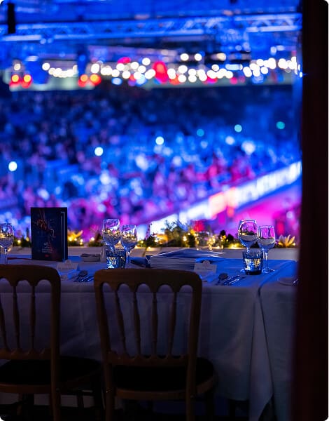 img - A dinner table elegantly set in a spacious arena